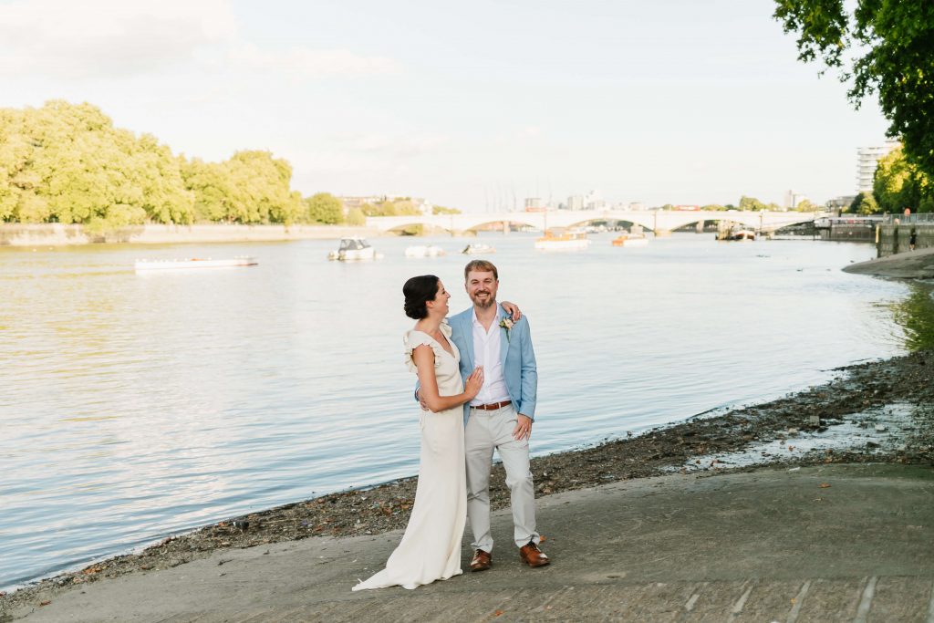 bride and groom standing in front of the putney embankment at their wedding