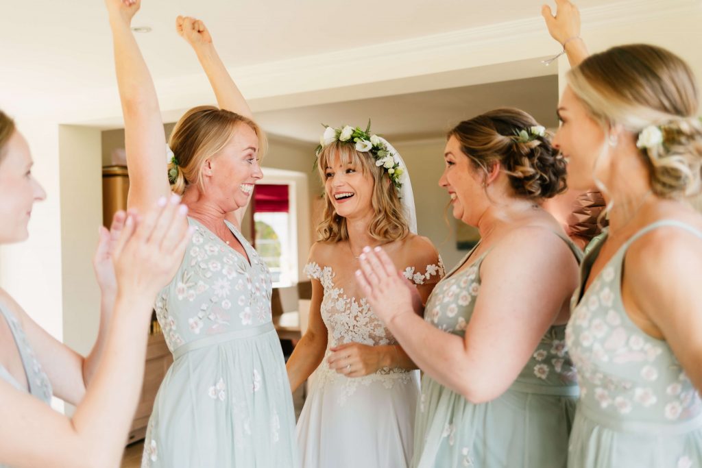 bride with bridesmaids excited before her wedding ceremony