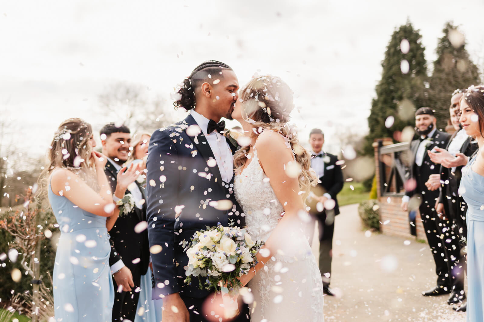 couple kissing under confetti. captured by documentary wedding photographer