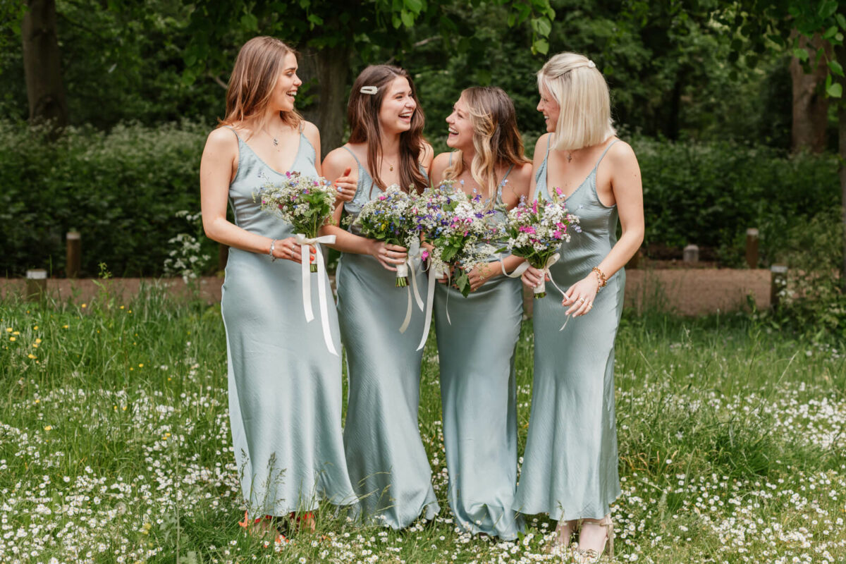 bridesmaids in green dresses holding flowers at orleans house gallery wedding twickenham