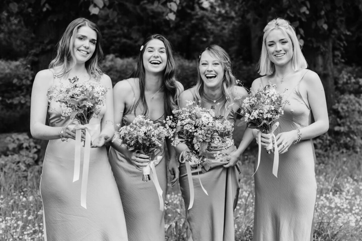 bridesmaids in green dresses holding flowers at orleans house gallery wedding twickenham
