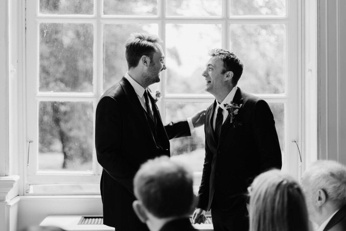 groom and best man laughing at Orleans house gallery wedding in twickenham