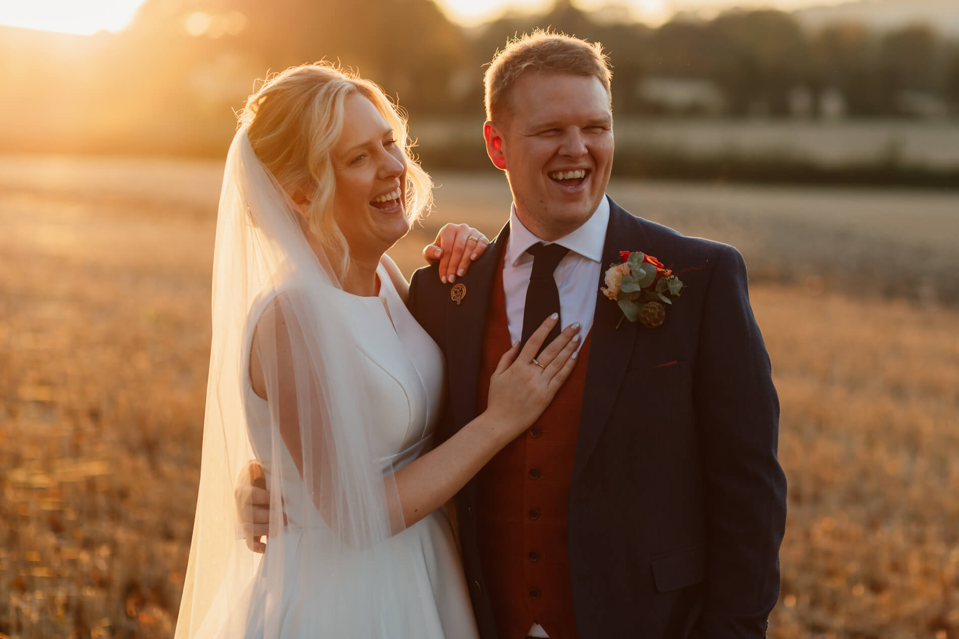 bride and groom in the sun set laughing