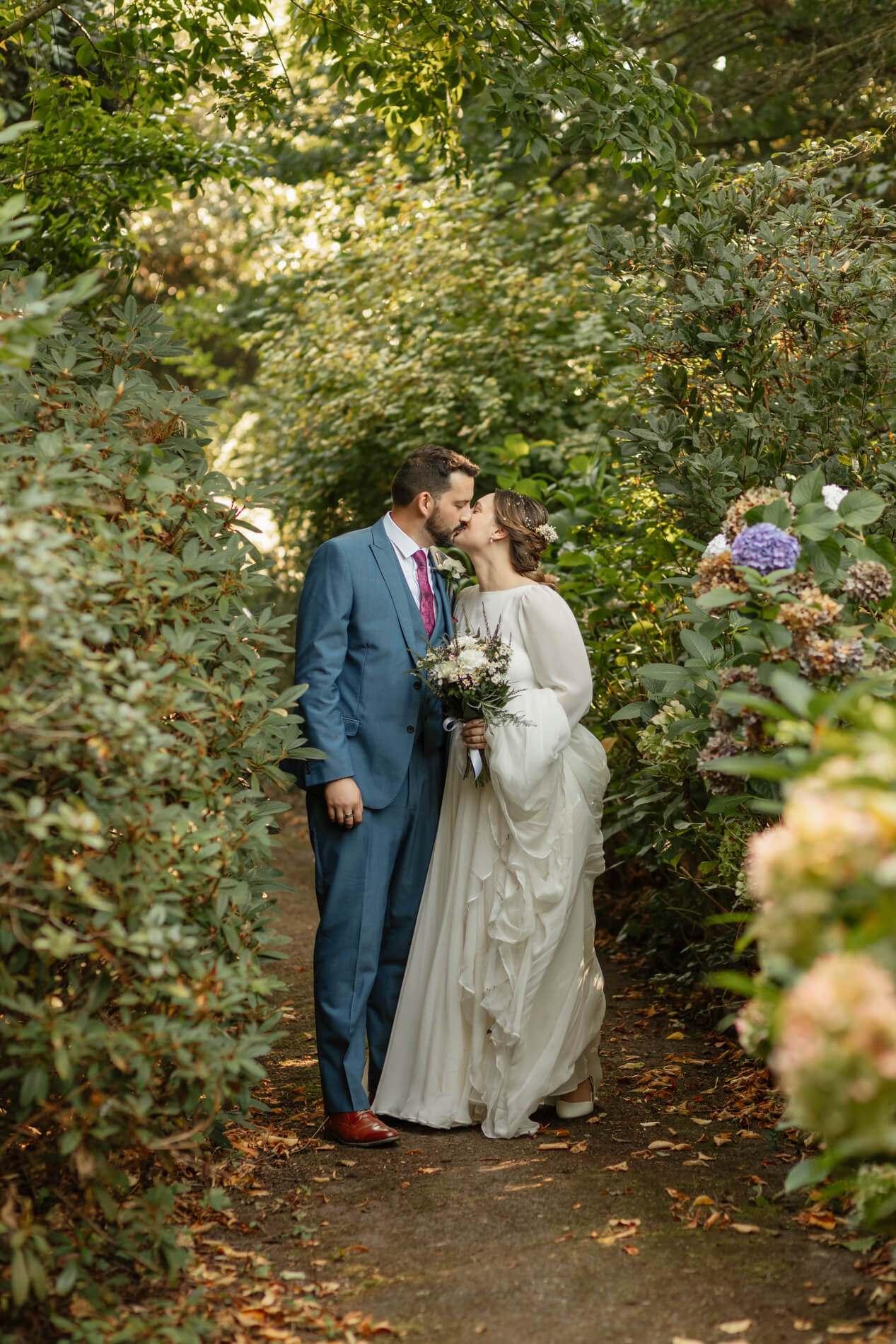 bride and groom kissing in woods