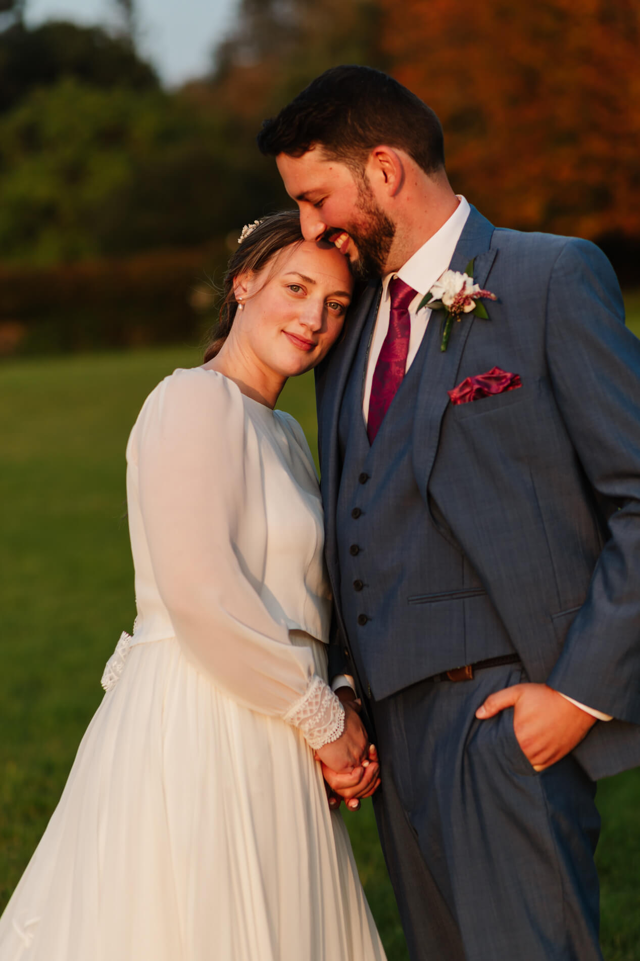 bride leaning into her groom looking at the camera