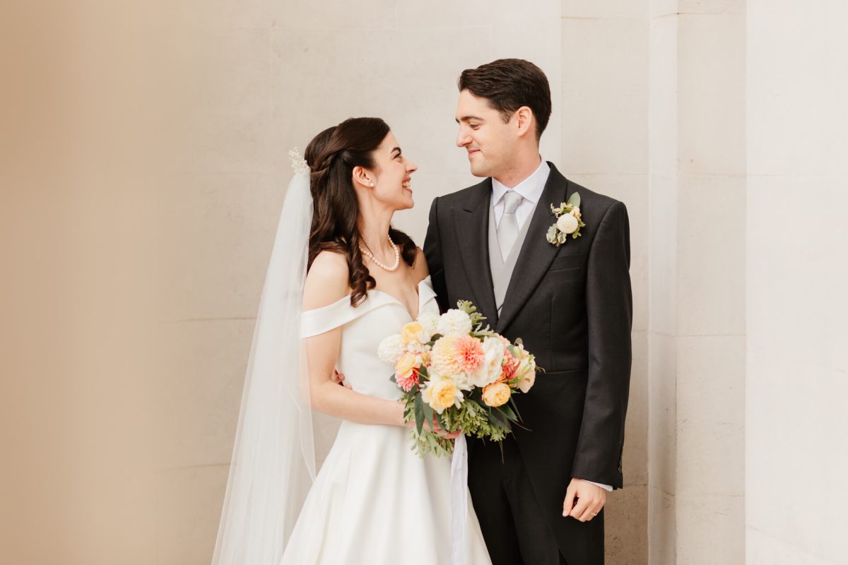 photograph of bride and groom smiling with each other