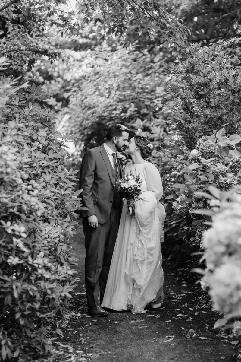 picture of bride and groom kissing in a flower garden
