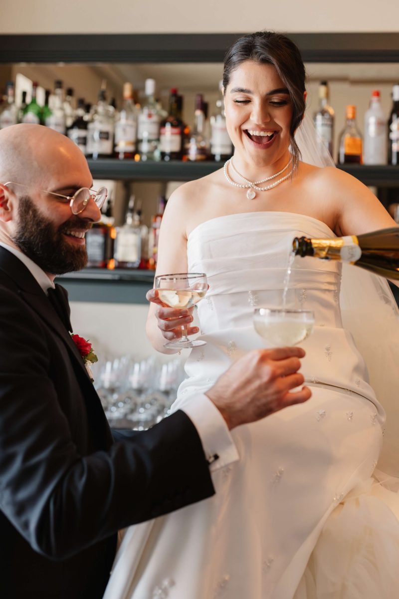 couple toasting champagne on their wedding day by claire wakefield west midlands wedding photographer
