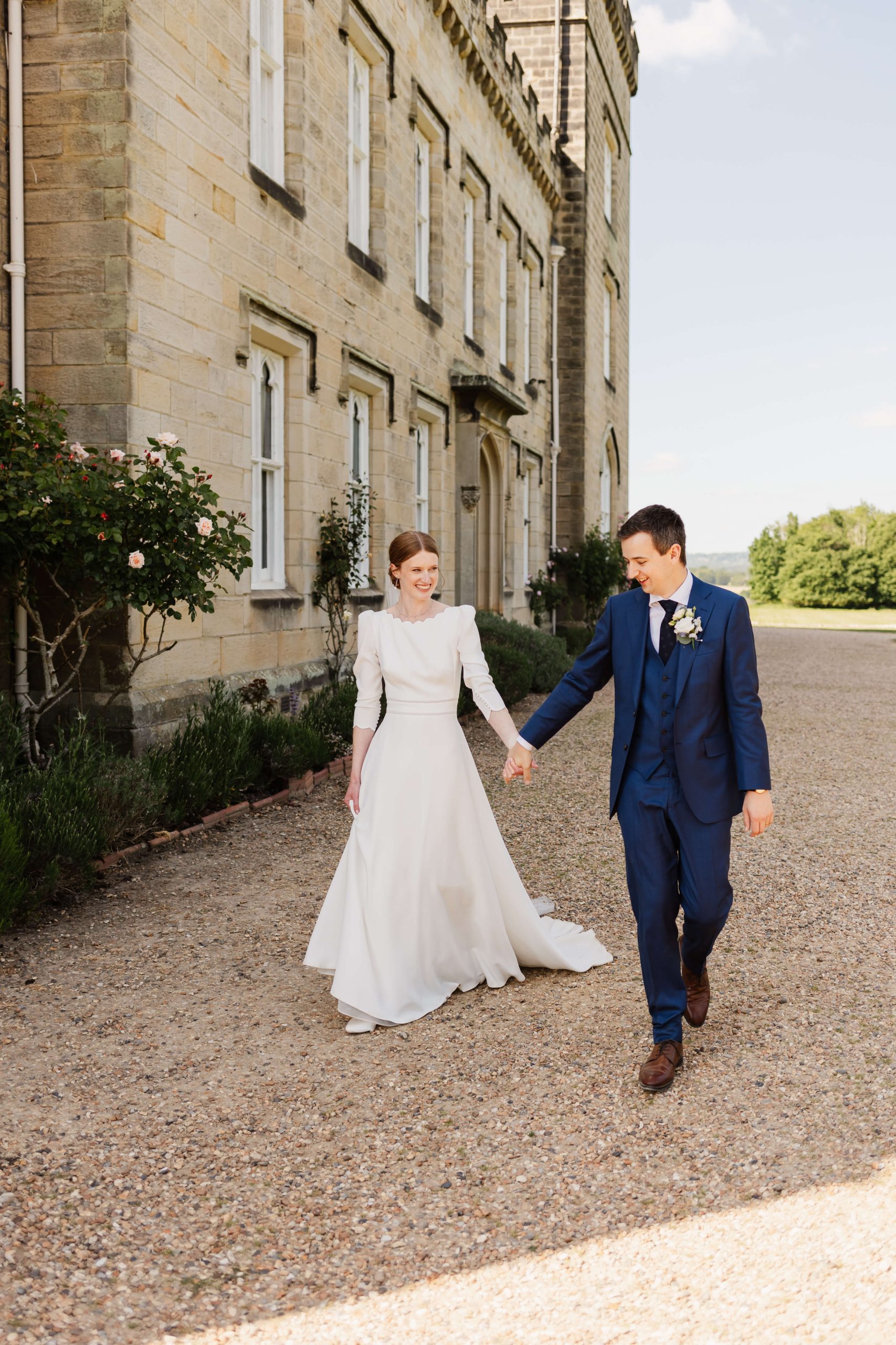 West midlands wedding photographer capturing bride and groom walking and smiling at chiddingstone castle