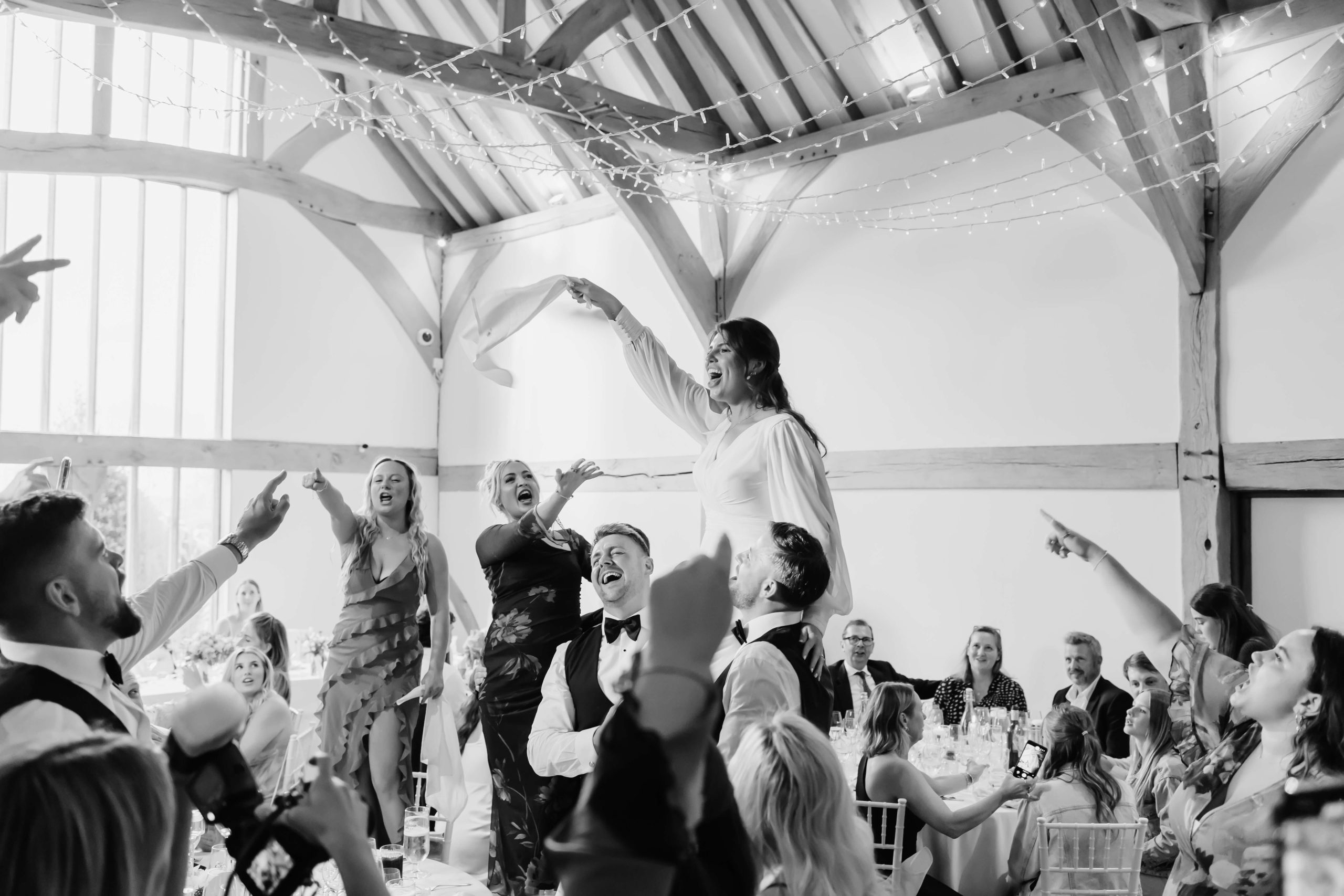 photograph of bride sitting on shoulders of groom and bestman. West midlands wedding photographer